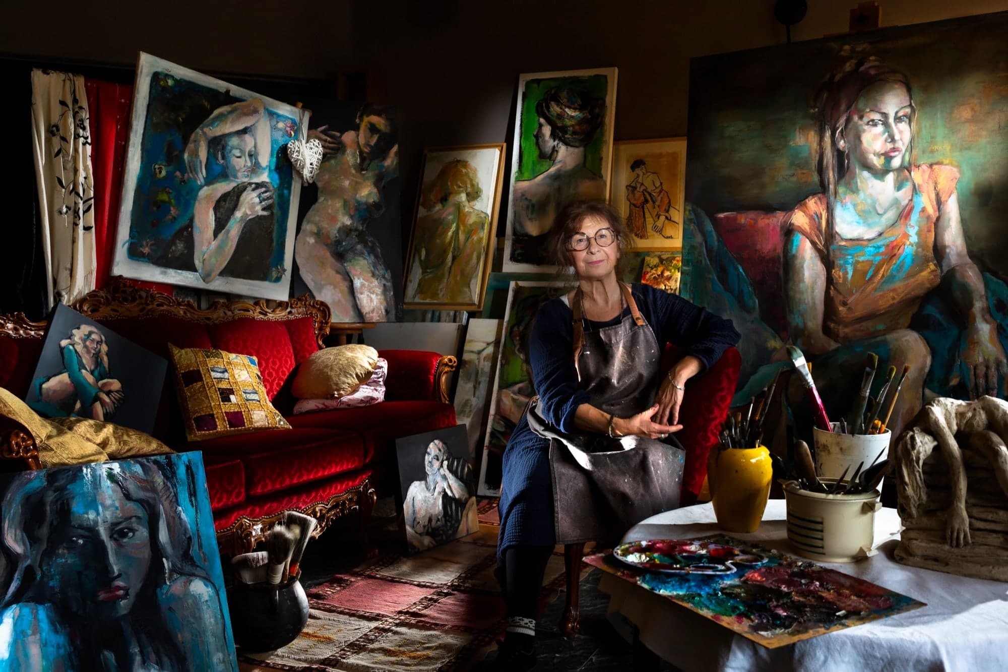 Portrait de Giovanna Grande, artiste peintre, entourée de ses toiles dans son atelier